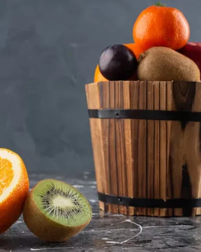cubo madera lleno frutas frescas sobre superficie marmol